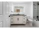 Bright bathroom with a modern vanity, black hardware, large lighted mirror, and a tiled shower/tub at 2528 Sunup Dr, Las Vegas, NV 89134