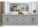 Close-up of bathroom vanity with dual sinks, gold fixtures, and bright lighting, complemented by a large mirror at 2528 Sunup Dr, Las Vegas, NV 89134