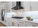 Modern kitchen with white cabinets, gold hardware, and a sleek black range hood at 2528 Sunup Dr, Las Vegas, NV 89134