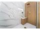 Luxurious shower featuring marble and wood-look tiles, a built-in bench, and modern fixtures at 2528 Sunup Dr, Las Vegas, NV 89134