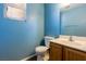 Cozy bathroom featuring blue walls, wood-look flooring, and a single sink vanity at 2608 Los Palos St, Las Vegas, NV 89108
