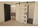 Bedroom showcasing a modern barn door, neutral carpet, and doorway to the bathroom at 2615 W Gary Ave # 1015, Las Vegas, NV 89123
