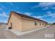 Side view of a home features a covered patio, ample windows, and desert landscaping at 3761 S Tumbleweed Ave, Pahrump, NV 89048