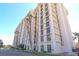 A multi-story building with classic architecture is surrounded by green space and trees, a clear blue sky at 3930 University Center Dr # 409, Las Vegas, NV 89119