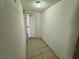 Tight hallway showing a utility door, basic tile flooring, overhead lighting, and textured walls at 3930 University Center Dr # 409, Las Vegas, NV 89119