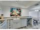 Modern kitchen features ample countertop space, white appliances, and view of the living area at 3930 University Center Dr # 409, Las Vegas, NV 89119