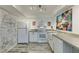 Well-lit kitchen with white cabinets, modern appliances, and whitewashed brick wall at 3930 University Center Dr # 409, Las Vegas, NV 89119