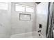 The bathroom features a shower-tub combination, stylishly accented with black fixtures and sleek white tiling at 4786 San Rafael Ave, Las Vegas, NV 89120