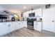 Well-lit kitchen with stainless steel appliances, white cabinets, modern fixtures, and hardwood style floors at 4786 San Rafael Ave, Las Vegas, NV 89120