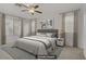 Serene bedroom featuring a king-sized bed, ceiling fan, and ample natural light from large windows at 4972 Groveland Ave, Las Vegas, NV 89139