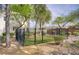 Fenced dog run in backyard features artificial turf, black metal fencing, and mature landscaping at 4972 Groveland Ave, Las Vegas, NV 89139