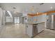 Spacious open-concept living area with tiled floors, modern kitchen, and a chandelier at 4972 Groveland Ave, Las Vegas, NV 89139