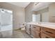 Bright bathroom with a wood vanity, a sink, a mirror, and a toilet with tile floors at 50 Aura De Blanco St # 19103, Henderson, NV 89074