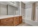 Bathroom featuring a single sink vanity with wood cabinets, a large mirror, and a shower-tub combination at 50 Aura De Blanco St # 19103, Henderson, NV 89074