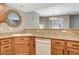Kitchen showcasing granite countertops, wooden cabinets, and stainless steel appliances, with an open view to living spaces at 50 Aura De Blanco St # 19103, Henderson, NV 89074