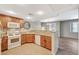 Well-lit kitchen featuring wood cabinets, granite countertops, and a view to the adjacent dining and living areas at 50 Aura De Blanco St # 19103, Henderson, NV 89074