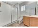 A bathroom featuring a shower with glass door, tile flooring, and wooden cabinet at 5588 Ness Ave, Las Vegas, NV 89118