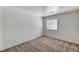 An empty bedroom with neutral carpet, window, and white walls, ready for personalization at 5588 Ness Ave, Las Vegas, NV 89118