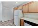 A functional kitchen featuring wooden cabinets, white appliances, and tile flooring at 5588 Ness Ave, Las Vegas, NV 89118