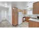 A functional kitchen featuring wooden cabinets, white appliances, and tile flooring at 5588 Ness Ave, Las Vegas, NV 89118