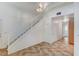 Bright living area with stairs leading to the second floor, light tile flooring, and natural lighting at 5588 Ness Ave, Las Vegas, NV 89118