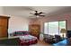 Comfortable bedroom with a ceiling fan and ample natural light from the large window at 5772 Flying Birdie Ave, Las Vegas, NV 89122