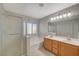 Bathroom featuring double sinks, granite counters, a tub and shower with glass doors at 6424 Bombax Ct, Las Vegas, NV 89141
