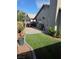 Spacious backyard featuring artificial turf, a paved patio with outdoor dining, and mature trees at 7136 Overhill, Las Vegas, NV 89129