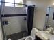 Bathroom featuring a modern walk-in shower with custom tile, black accents, and updated fixtures at 7136 Overhill, Las Vegas, NV 89129