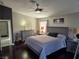 Comfortable main bedroom with ceiling fan, ensuite access, dark wood floors, and ample natural light at 7136 Overhill, Las Vegas, NV 89129