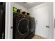 This laundry room features a sleek, modern, black washer and dryer, with storage space and a door at 7237 Puddle Duck St, Las Vegas, NV 89166