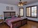Cozy bedroom with hardwood floors, ceiling fan, and natural light from shuttered windows at 7660 Descanso Ln, Las Vegas, NV 89123