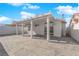 Backyard view of the covered patio with concrete and stone pavers, adjacent to white privacy walls at 8127 Chambersberg St, Las Vegas, NV 89147