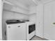 Clean laundry room with modern washer, dryer, shelving and white painted doors at 8127 Chambersberg St, Las Vegas, NV 89147