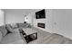 Cozy living room with a gray sectional, modern fireplace, and sleek wood-look flooring at 8127 Chambersberg St, Las Vegas, NV 89147
