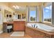 This primary bathroom features a soaking tub with windows and a vanity with drawers and cabinets at 884 Loma Bonita Pl, Las Vegas, NV 89138