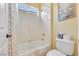 Bright bathroom featuring a white tiled shower/tub and toilet at 884 Loma Bonita Pl, Las Vegas, NV 89138