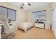 Bright bedroom features a ceiling fan, a desk, and natural light from two windows at 884 Loma Bonita Pl, Las Vegas, NV 89138