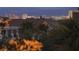 This evening city view looks out over lush landscaping and terra cotta rooftops at 884 Loma Bonita Pl, Las Vegas, NV 89138