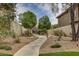Inviting community entrance with a paved walkway, mature trees, and manicured landscaping at 884 Loma Bonita Pl, Las Vegas, NV 89138