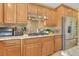 Modern kitchen featuring stainless steel appliances, stone backsplash, and maple cabinets at 884 Loma Bonita Pl, Las Vegas, NV 89138