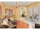 Cozy living room featuring a leather sofa, chandelier, and access to the patio at 884 Loma Bonita Pl, Las Vegas, NV 89138