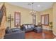 Elegant living room with a leather sectional, chandelier, and natural lighting at 884 Loma Bonita Pl, Las Vegas, NV 89138