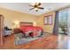 Comfortable main bedroom featuring hardwood floors, ceiling fan and sliding door to a balcony at 884 Loma Bonita Pl, Las Vegas, NV 89138
