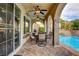 Covered patio area features an outdoor dining table and chairs with a swimming pool in the background at 884 Loma Bonita Pl, Las Vegas, NV 89138