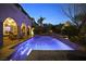 Backyard pool with blue lighting, patio with seating, and lush landscaping at 884 Loma Bonita Pl, Las Vegas, NV 89138