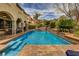 Backyard view of the pool with a lovely waterfall feature and covered patio area at 884 Loma Bonita Pl, Las Vegas, NV 89138