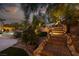 Relaxing backyard features a brick stairway, lush landscaping, and a sparkling pool surrounded by mature trees at 9 Chalet Hills Ter, Henderson, NV 89052