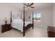 Bedroom with light wood floors, a dark wood bed, and natural light streaming through the window at 9 Chalet Hills Ter, Henderson, NV 89052