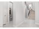 Bright hallway featuring tile flooring, staircase with iron spindles, and access to a half bathroom at 9 Chalet Hills Ter, Henderson, NV 89052